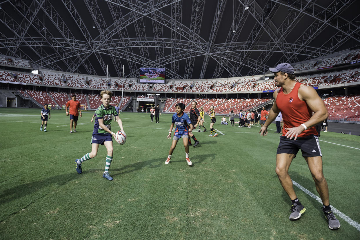 Former New Zealand All Blacks Sevens player, Murphy Taramai and former South African Sevens team-member Carel du Preez play a round of touch rugby with kids from eight local rugby. (PHOTO: HSBC Singapore Rugby Sevens)