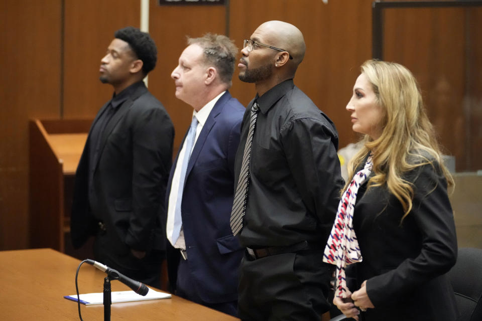 Juan Rayford, second from right, and Dupree Glass, far left, stand with their attorneys Eric Dubin, second from left, and Annee Della Donna, right, as the judge walks in the courtroom during a hearing on their case at the Clara Shortridge Foltz Criminal Justice Center Thursday, April 20, 2023, in Los Angeles. Rayford and Glass were convicted of attempted murder and sentenced to 11 consecutive life sentences. They served 17 years in prison before being released in 2020 after a judge ruled they were wrongfully convicted. (AP Photo/Marcio Jose Sanchez)