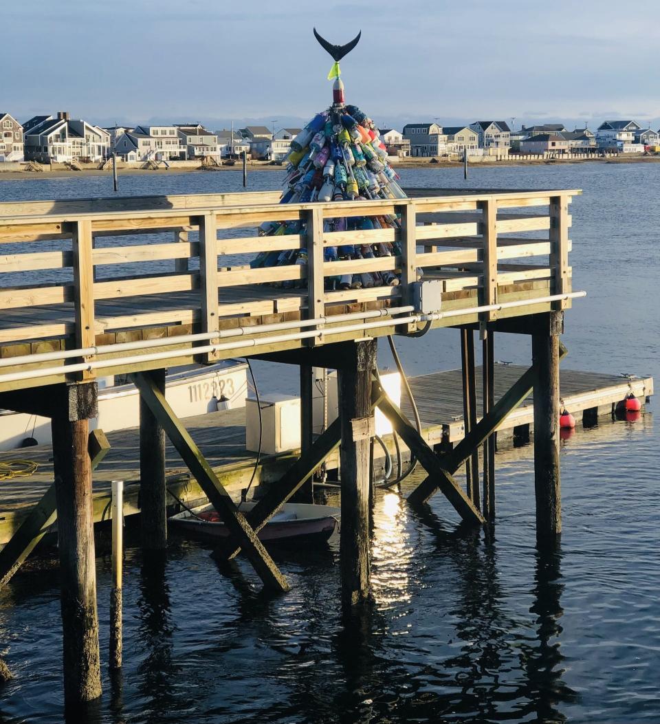 The severed, dried tail of a tuna sits atop the buoy-inspired Christmas tree on display at Wells Harbor in Wells, Maine, on Dec. 6, 2023.