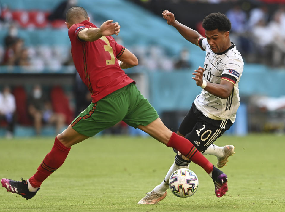 Portugal's Pepe, left, tries to tackle Germany's Serge Gnabry during the Euro 2020 soccer championship group F match between Portugal and Germany at the football arena stadium in Munich, Saturday, June 19, 2021. (Christof Stache/Pool via AP)