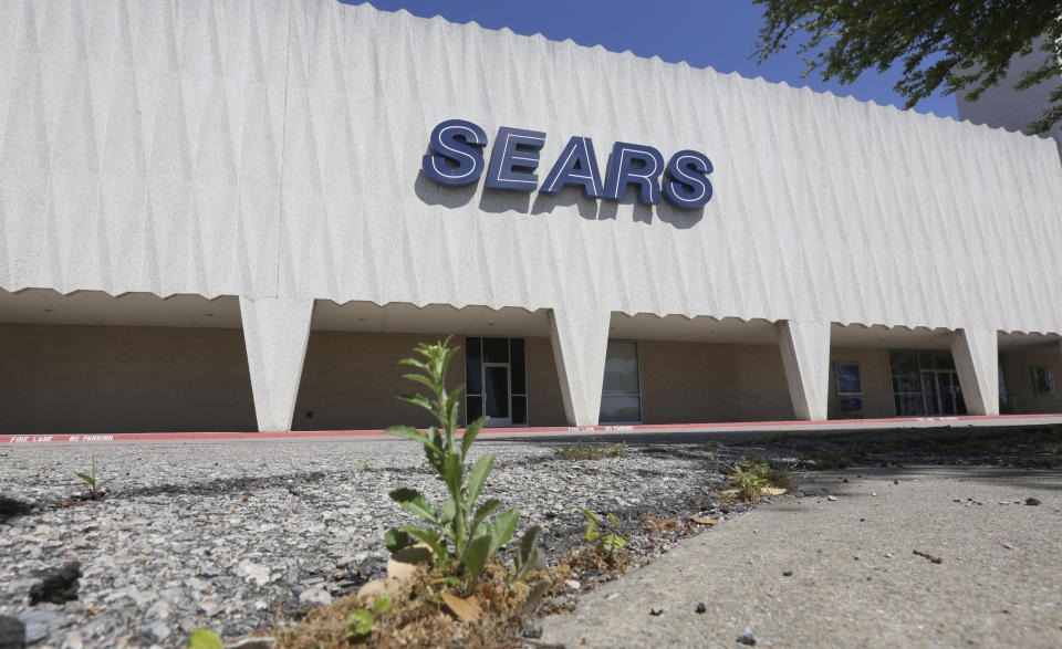 FILE- In this March 23, 2017, file photo a small weed grows in the parking lot outside a Sears retail store in north Dallas. Sears’ Chapter 11 bankruptcy filing on Monday, Oct. 15, 2018, will have rippling effects on everything from its workers to suppliers. The restructuring plan, which calls for another 142 store closures by year-end, will reduce the company to a little over 500 stores, a dramatic drop from its peak of 4,000 stores in 2012. (AP Photo/LM Otero, File)