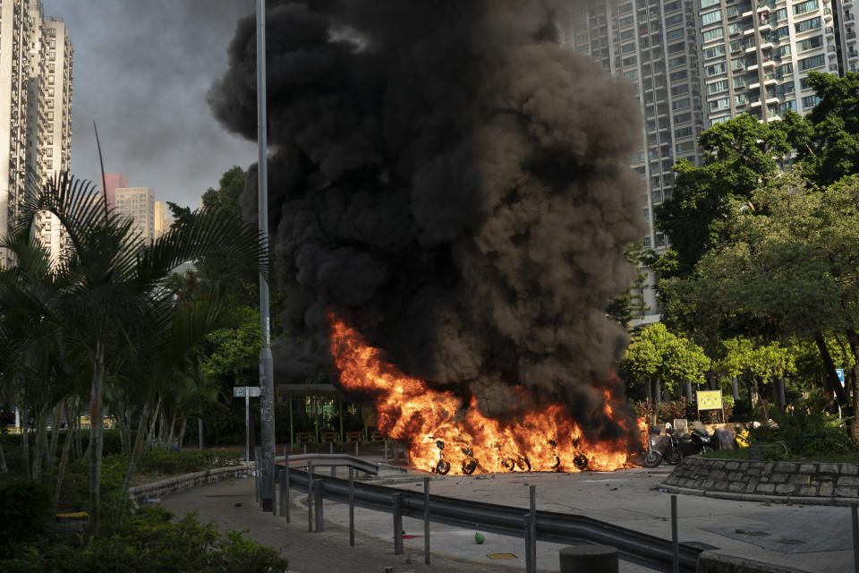 A row of motor-cycles go up in flames as anti-government protesters clash with police in Hong Kong, Oct. 1, 2019. (Photo: Felipe Dana/AP)