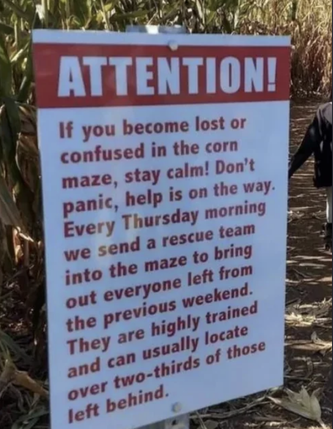 Sign reading: Attention! Rescue team enters the corn maze every Thursday to find lost visitors from the previous weekend. Stay calm