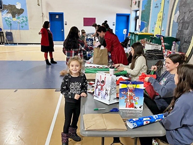 Gonic Elementary Kindergartener Sophia Gelinas smiles as she has presents for her family wrapped by staff members during the shopping spree.