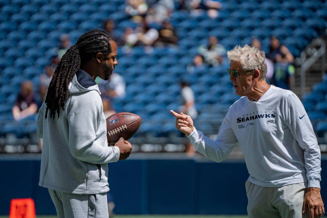 Richard Sherman talks to Seattle Seahawks coach Pete Carroll at Lumen Field before the Seahawks’ practice game on Saturday Aug. 6, 2022 in Seattle, Wash.