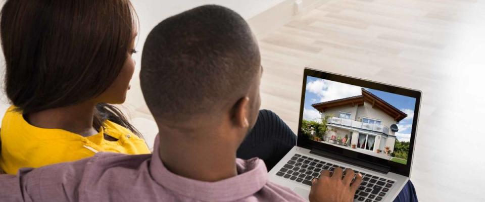 Young Couple Looking At House On Laptop's Screen