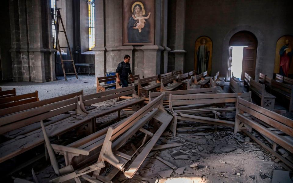 A man walks in rubble on October 8, 2020 inside the Ghazanchetsots (Holy Saviour) Cathedral in the historic city of Shusha, some 15 kilometers from the disputed Nagorno-Karabakh province's capital Stepanakert - AFP