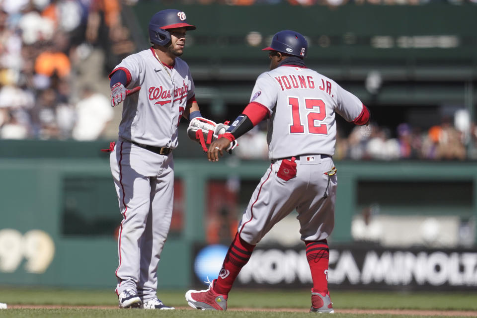 Washington Nationals' Yadiel Hernandez, left, is congratulated by first base coach Eric Young Jr. (12) after hitting a three-run double against the San Francisco Giants during the eighth inning of a baseball game in San Francisco, Sunday, May 1, 2022. (AP Photo/Jeff Chiu)