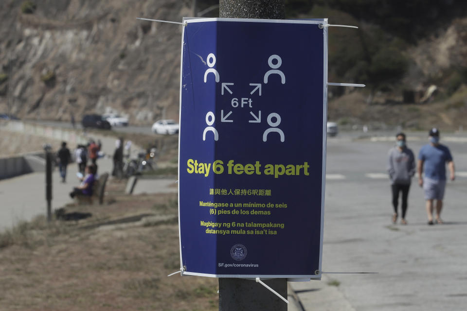 A sign advising social distance is posted at a closed parking lot to Ocean Beach during the coronavirus outbreak, in San Francisco, Sunday, July 5, 2020. Californians mostly heeded warnings to stay away from beaches and other public spaces during the long weekend as state officials urged social distancing amid a spike in coronavirus infections and hospitalizations. (AP Photo/Jeff Chiu)