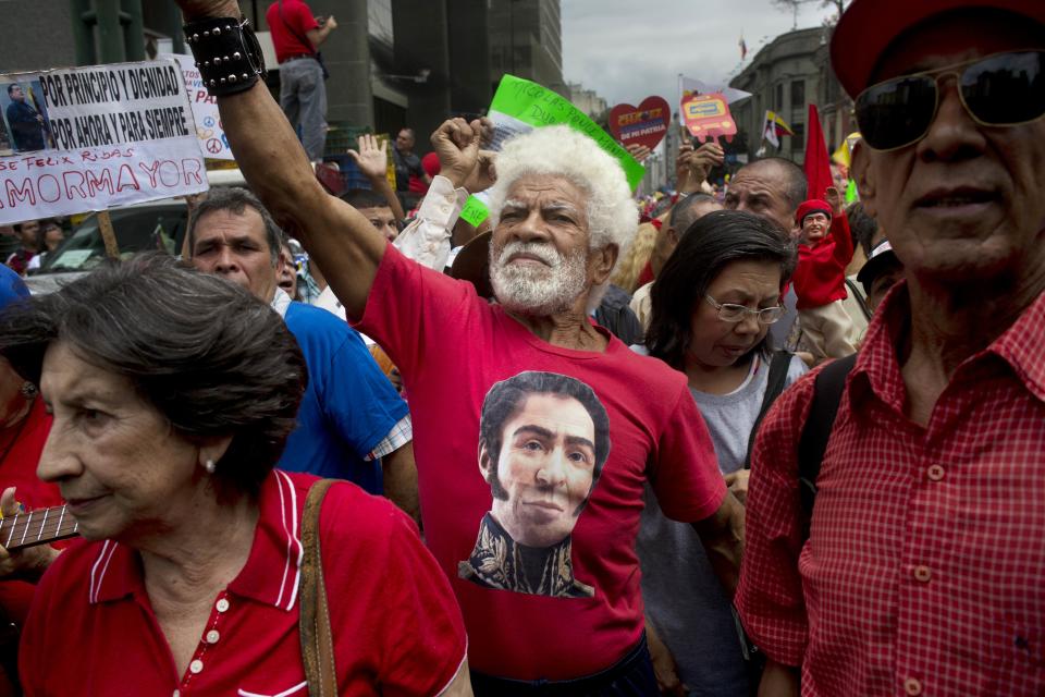 Un hombre vestido con una camiseta con la imagen del héroe independentista de Venezuela Simón Bolivar entona cánticos oficialistas durante una marcha organizada por el gobierno en Caracas, Venezuela, el domingo 23 de febrero de 2014. (Foto AP/Rodrigo Abd)