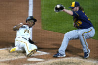 Milwaukee Brewers starting pitcher Corbin Burnes (39) takes the throw from catcher Omar Narvaez as Pittsburgh Pirates' Ke'Bryan Hayes scores from third on a wild pitch during the sixth inning of a baseball game in Pittsburgh, Friday, July 1, 2022. (AP Photo/Gene J. Puskar)