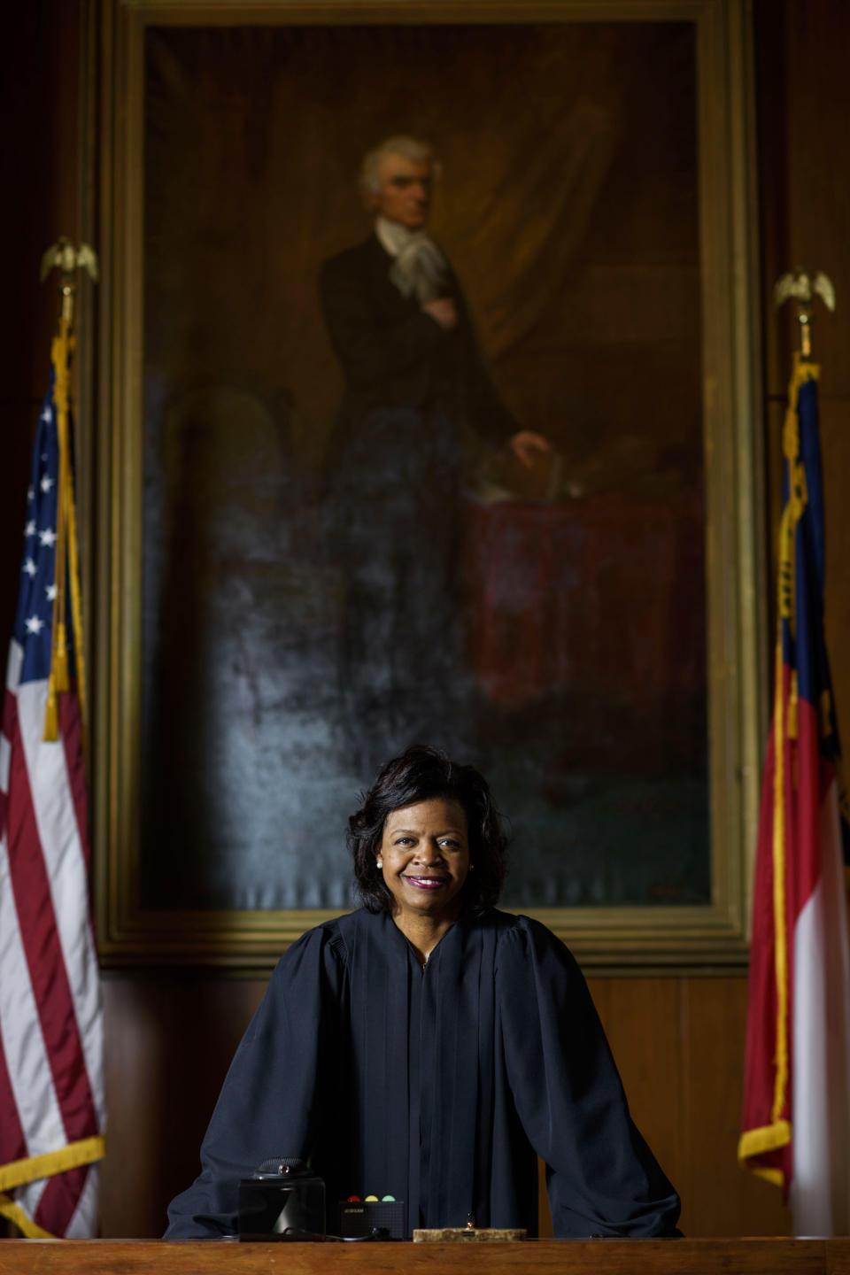 FILE - In this Feb. 13, 2019, file photo, Cheri Beasley poses for a portrait in the court room from the Chief Justice's seat in Fayetteville, N.C. In North Carolina's Supreme Court chamber, above the seat held by Beasley, the second African American chief justice, hangs a towering painting of Chief Justice Thomas Ruffin, a 19th century slave owner and jurist who authored a notorious opinion about the “absolute” rights of slaveholders over the enslaved. In October 2018 the state Supreme Court named a commission to review the portraits in the building that houses the court,including Ruffin's. (Melissa Sue Gerrits/The Fayetteville Observer via AP, File)