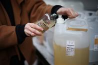 Ella Shone, fills a customers container with soap from her zero waste mobile shop 'Top Up Truck' in London