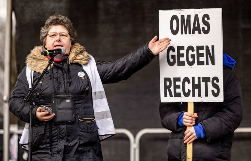 Transformationsforscherin und Politökonomin Maja Koppel steht neben einer Gestenlesung auf der Bühne. "Großmutter gegen rechts", während einer Demonstration gegen Rechtsextremismus.  Axel Heimken/dpa