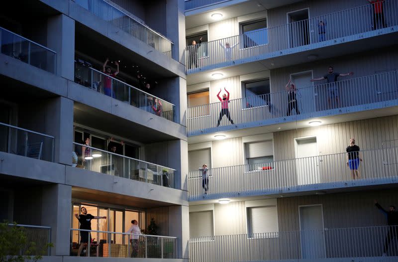 Residents exercise on their balconies following fitness trainers in Nantes