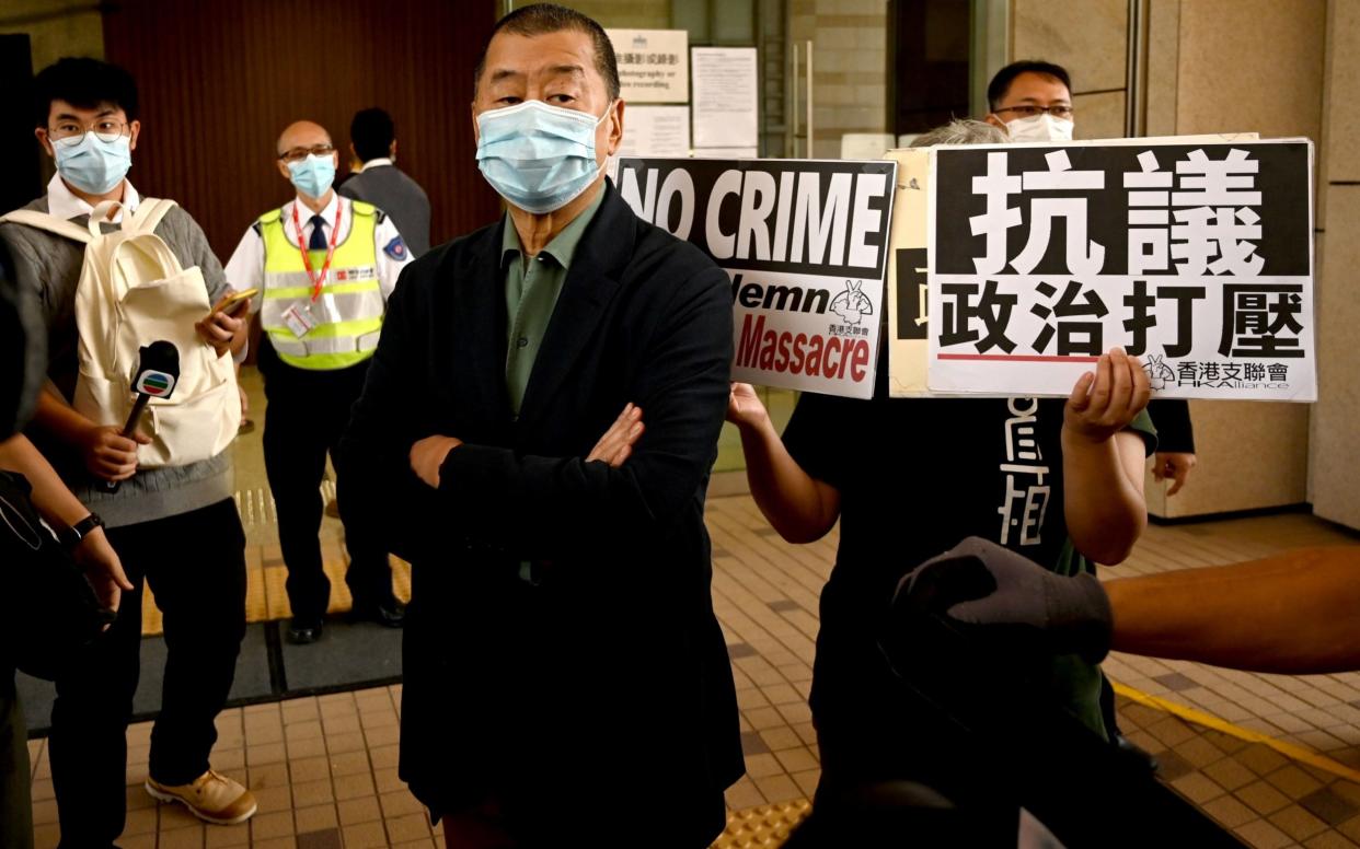 Jimmy Lai (centre) looks on as activists demonstrate outside a court in Hong Kong in November - PETER PARKS /AFP