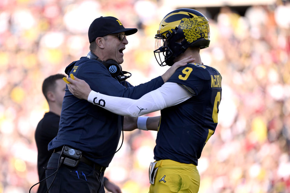 Michigan head coach Jim Harbaugh, left, celebrates with quarterback J.J. McCarthy (9) after a touchdown catch by running back Blake Corum during the first half of the Rose Bowl CFP NCAA semifinal college football game against Alabama Monday, Jan. 1, 2024, in Pasadena, Calif. (AP Photo/Kyusung Gong)