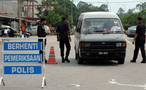 Malaysian police officers look for escaped illegal immigrants near the Lenggeng detention depot at Broga, south of Kuala Lumpur last month. Malaysia is to offer amnesty to some of its two million illegal immigrants in a plan to ease labour shortages in the plantation and service industries