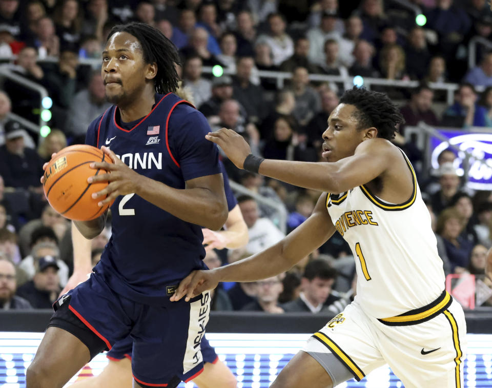 UConn guard Tristen Newton (2) drives past Providence guard Jayden Pierre (1) during the second half of an NCAA college basketball game, Saturday, March 9, 2024, in Providence, R.I. (AP Photo/Mark Stockwell)