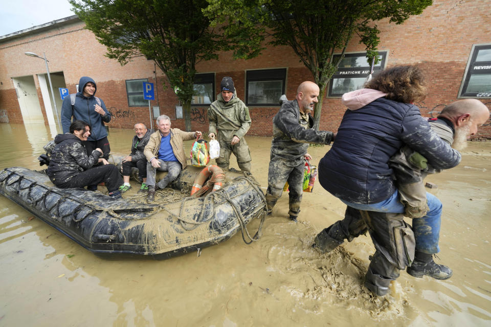 People are rescued in Faenza, Italy, Thursday, May 18, 2023. Exceptional rains Wednesday in a drought-struck region of northern Italy swelled rivers over their banks, killing at least nine people, forcing the evacuation of thousands and prompting officials to warn that Italy needs a national plan to combat climate change-induced flooding. (AP Photo/Luca Bruno)