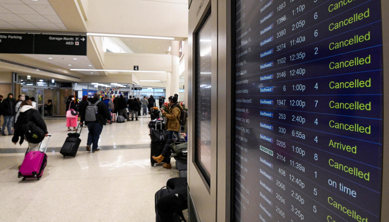 Passengers pulling their suitcases behind them arrive for a Southwest flight. 