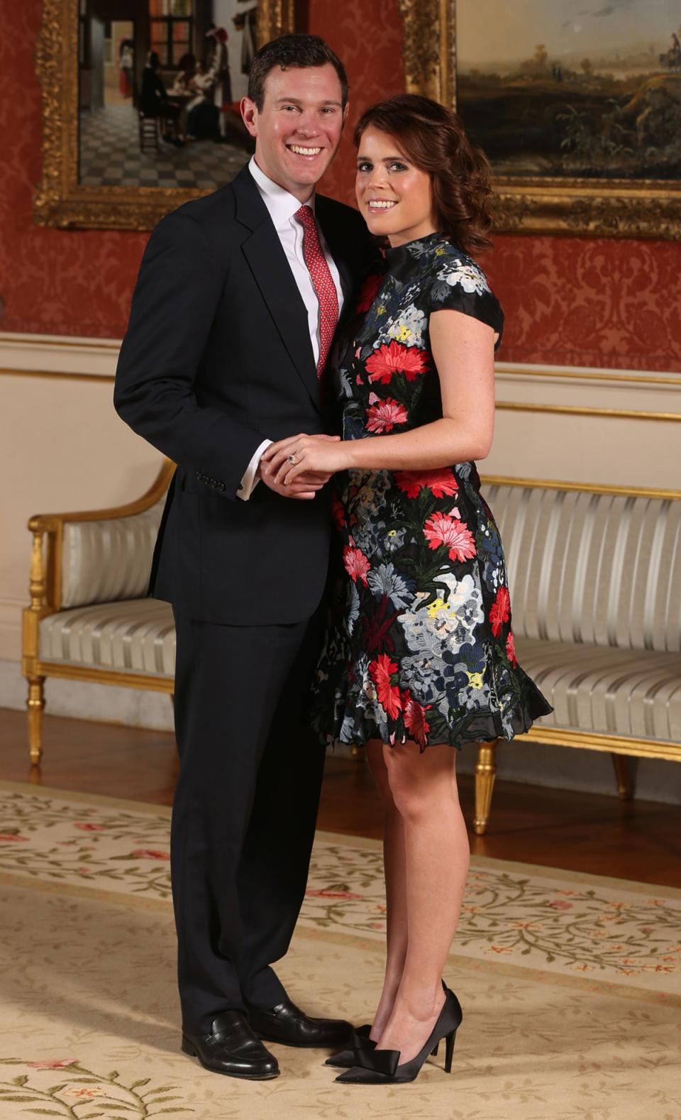 Princess Eugenie and Jack Brooksbank in the Picture Gallery at Buckingham Palace in London after they announced their engagement. Princess Eugenie wears a dress by Erdem, shoes by Jimmy Choo and a ring containing a padparadscha sapphire surrounded by diamonds (PA )