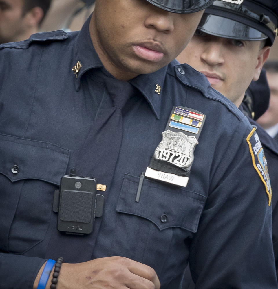 FILE - In this April 27, 2017 file photo, a police officer wears a body camera as he leaves the 34th precinct in New York. A New York appeals court has ruled that police body camera footage is subject to public disclosure under state law. (AP Photo/Mary Altaffer, File)