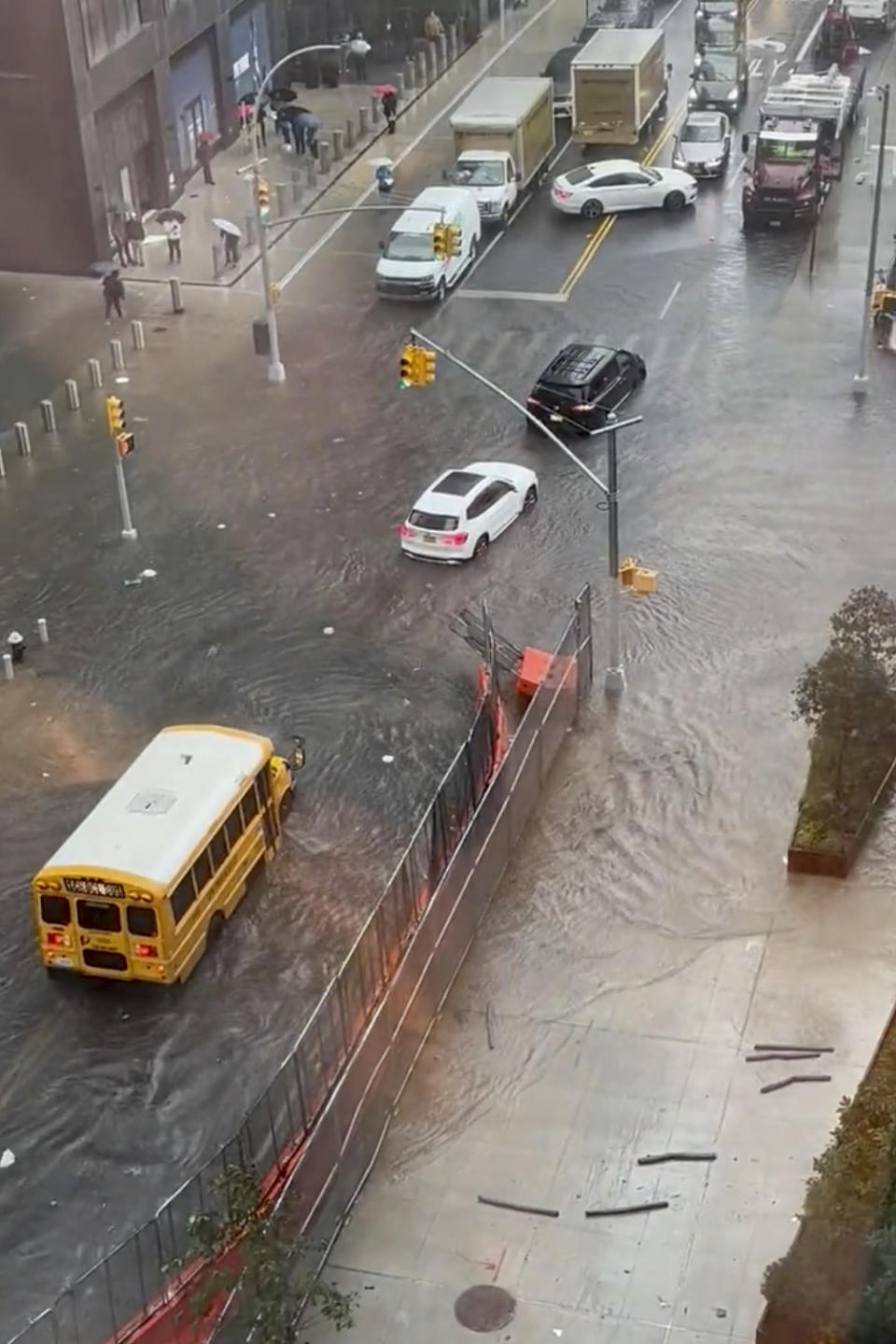 Vehicles including a school bus try to maneuver on a flooded street in Prospect Heights section of the Brooklyn borough of New York, Friday, Sept. 29, 2023. A potent rush-hour rainstorm has swamped the New York metropolitan area. The deluge Friday shut down swaths of the subway system, flooded some streets and highways, and cut off access to at least one terminal at LaGuardia Airport. (Courtesy of Jonathan Gardner via AP)