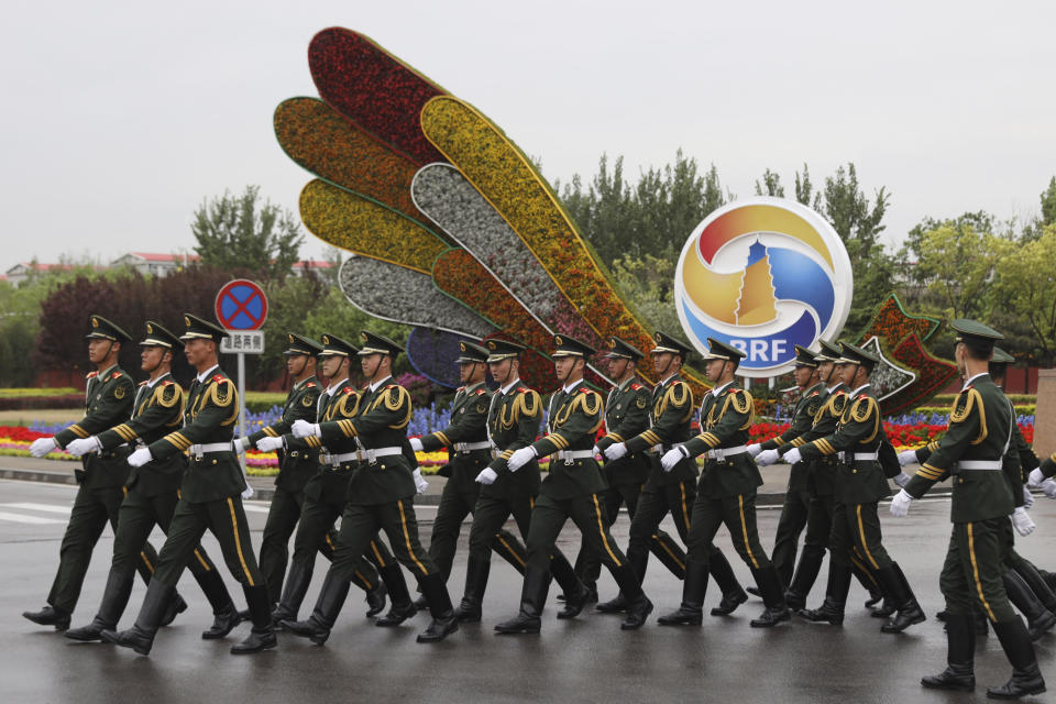 Chinese paramilitary policemen march past a decor for the Belt and Road Forum outside the special plane terminal of the Beijing International airport where foreign leaders are expected to arrive in Beijing on Wednesday, April 24, 2019. (AP Photo/Ng Han Guan, Pool)