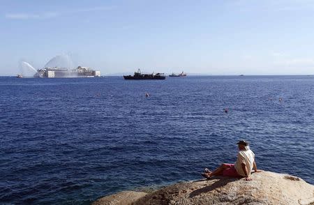 A man watches the cruise liner Costa Concordia during the refloat operation maneuvers at Giglio Island July 23, 2014. REUTERS/ Max Rossi