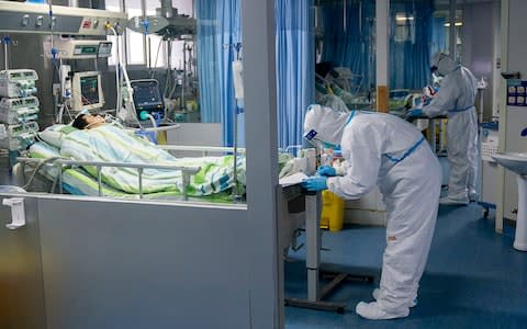 A medical worker attends to a patient in the intensive care unit at Zhongnan Hospital of Wuhan University  - Credit: &nbsp;Xiong Qi