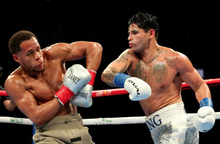 Ryan Garcia (white trunks) punches Devin Haney (gray trunks) on the way to a majority decision victory in their super-lightweight bout in Brooklyn, New York (AL BELLO)