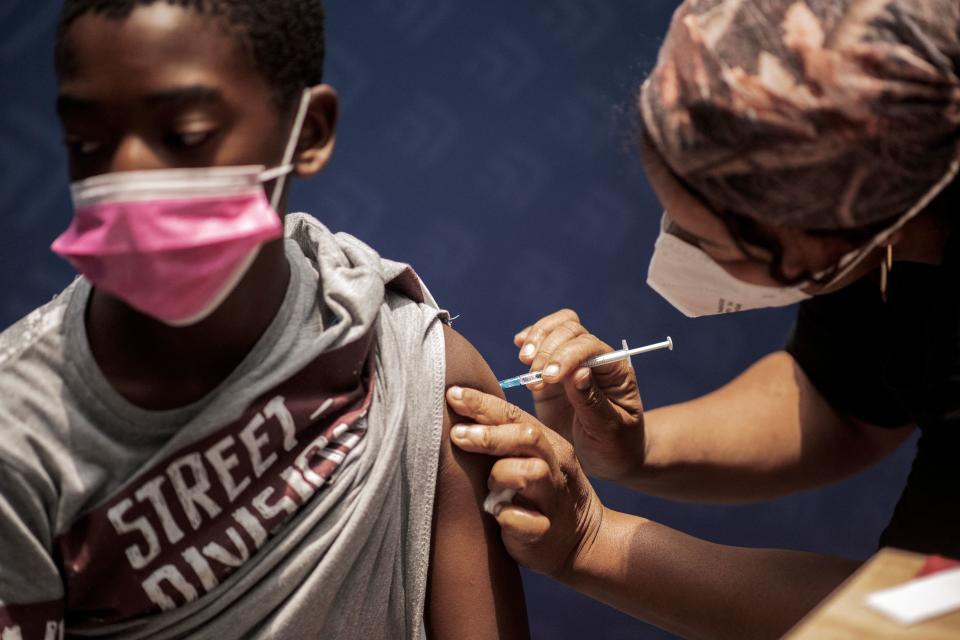 A boy receives a dose of the Pfizer/BioNTech vaccine against COVID-19 at Discovery vaccination site in Sandton, Johannesburg, on December 15, 2021. - Two shots of Pfizer's Covid vaccine offers around 70 percent protection against severe disease from Omicron, according to results of a study published December 14, 2021 in South Africa. The emergence of the highly mutated variant, first detected in South Africa last month, sparked fears that it could cause severe disease, be more contagious or could evade vaccines. (Photo by LUCA SOLA / AFP) (Photo by LUCA SOLA/AFP via Getty Images)