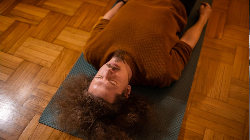 Man lying on the floor in his living room and trying some Kegel exercises