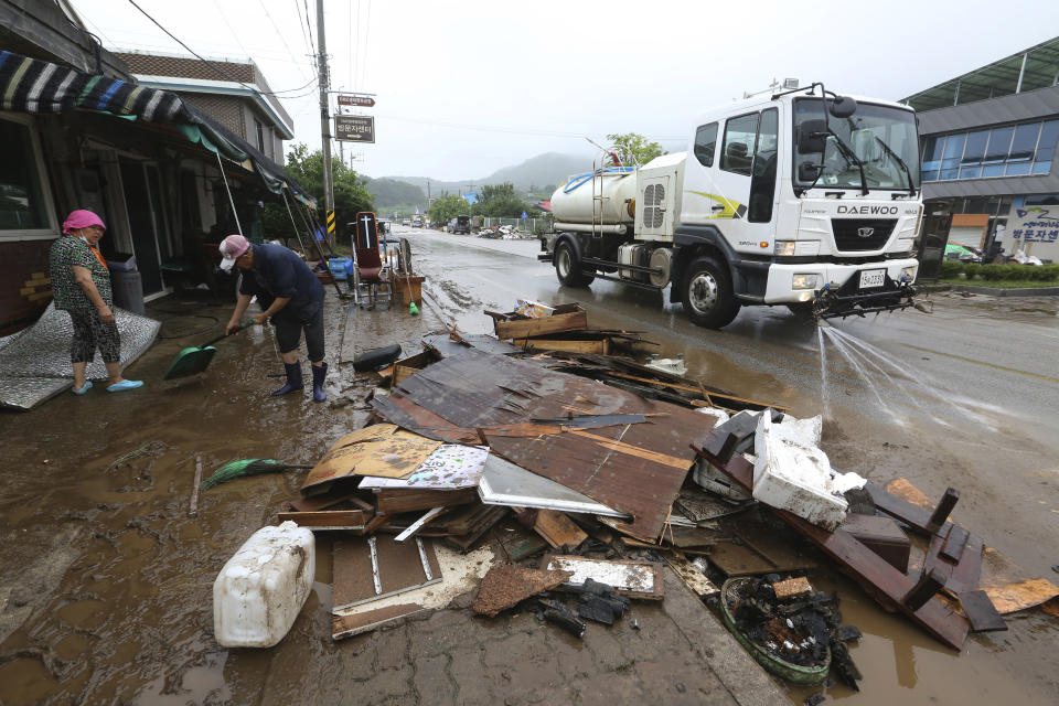 Residents scrape mud away from a damaged house following heavy rains in Cheorwon, South Korea, Thursday, Aug. 6, 2020. Torrential rains continuously pounded South Korea on Thursday, prompting authorities to close parts of highways and issue a rare flood alert near a key river bridge in Seoul. (AP Photo/Ahn Young-joon)