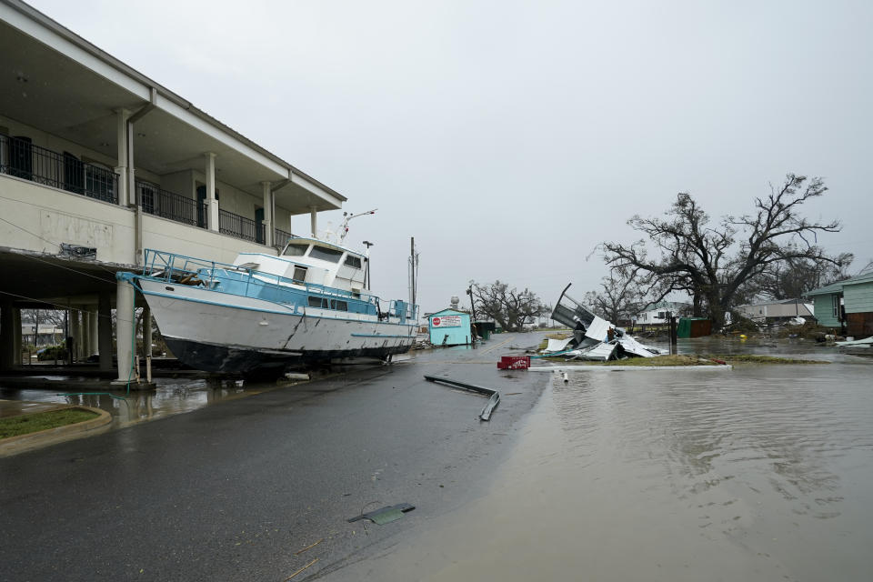 Flooding surrounds a damaged building and boat Friday, Aug. 28, 2020, in Cameron, La., after Hurricane Laura moved through the area Thursday. (AP Photo/David J. Phillip)