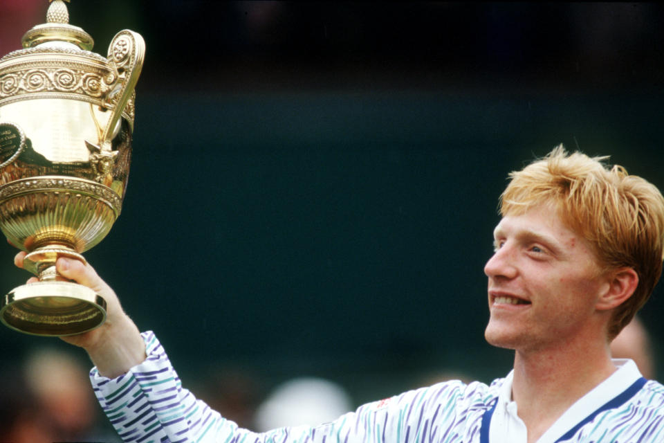 Boris Becker (piuctured) lifts the Wimbledon men's singles trophy for the third time after beating Stefan Edberg in straight sets.