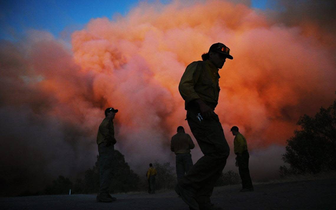 US Forest firefighters stand along Triangle Road watching the Oak Fire burn east of MidPines Friday, July 22, 2022 near Mariposa.