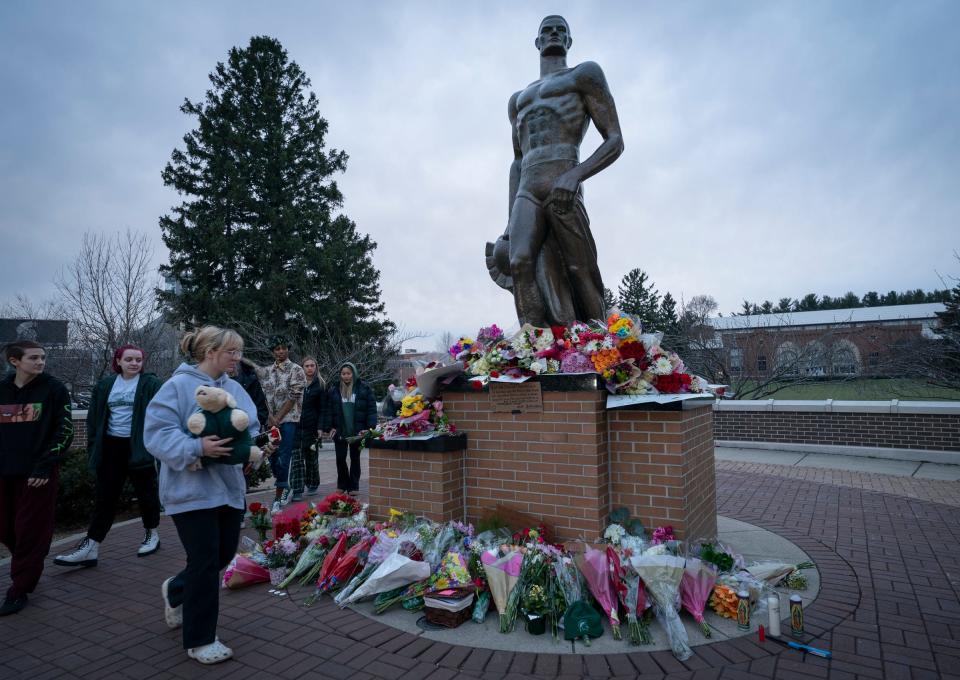 Jo Kovach, 21, a social relations and policy senior from Lincoln Park, brought a stuffed animal to gift to a makeshift memorial at The Spartan statue on the campus of Michigan State Tuesday, Feb. 14, 2023 a day after a gunman killed three MSU students and injured 5 more people.