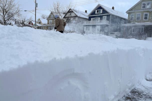 PHOTO: Martin Haslinger clears snow from the front of his home, Sunday, Dec. 25, 2022, in Buffalo, N.Y. (Bridget Haslinger/AP)