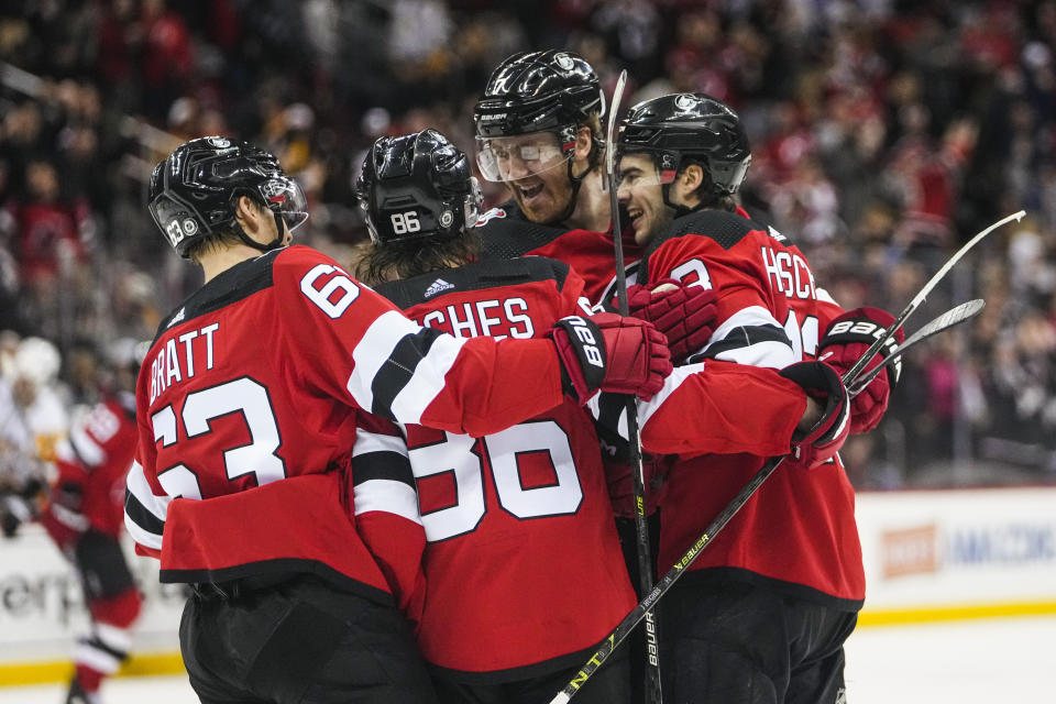 New Jersey Devils' Dougie Hamilton, center, celebrates with Jesper Bratt, Jack Hughes and Nico Hischier after scoring the game-winning goal during the overtime period of an NHL hockey game, Sunday, Jan. 22, 2023, in Newark, N.J. The Devils won 2-1 in overtime. (AP Photo/Frank Franklin II)