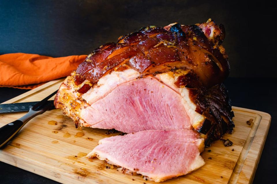 Glazed ham on a cutting board; (Source: Adobe Stock)