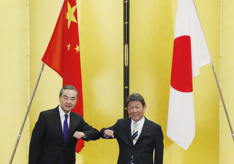 China' Foreign Minister Wang Yi, left, and his Japanese counterpart Toshimitsu Motegi bump elbows at the start of their talks amid the coronavirus outbreak, in Tokyo on Tuesday, Nov. 24, 2020. Wang met Motegi on Tuesday to discuss ways to revive their pandemic-hit economies as well as regional concerns over China’s growing influence. (Issei Kato/Pool Photo via AP)