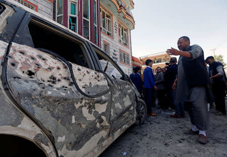 Afghan men inspect the site of a suicide bomb blast in Kabul, Afghanistan April 22, 2018. REUTERS/Omar Sobhani