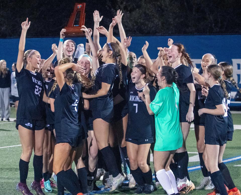 Lakeland Christian's KJ Straub holds up the trophy after the Vikings defeated Santa Fe Catholic, 5-0, on Thursday to win the Class 2A, Districtd 7 championship match at Viking Stadium.