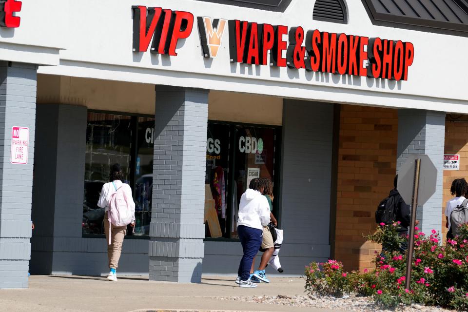 Teens walk by a vape and smoke shop across the street from Winton Woods High School along Kemper Road, Tuesday, Sept. 26, 2023, in Forest Park, Ohio. The Enquirer found that the majority, or 59%, of stores cited by the FDA for selling tobacco products to minors during the last four years are within 1 mile of a local middle or high school.