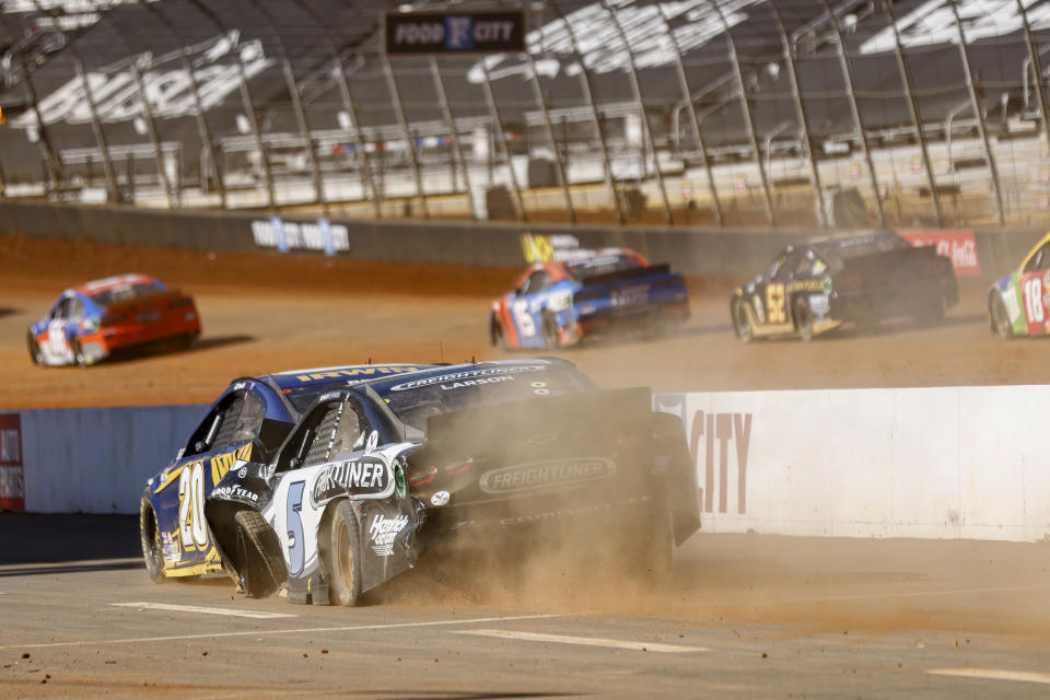 Driver Kyle Larson (5) pushes Christopher Bell (20) down pit road after a wreck during a NASCAR Cup Series auto race, Monday, March 29, 2021, in Bristol, Tenn. (AP Photo/Wade Payne)