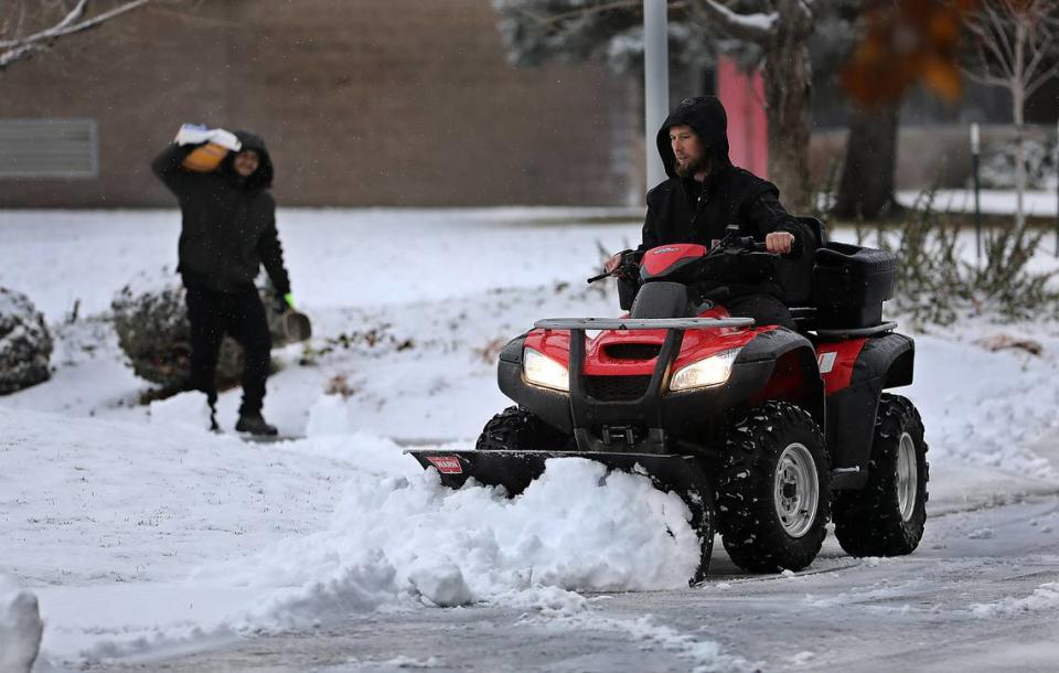 A pair of employees at the campus of the Toyota Center and Three Rivers Convention Center team up to clear snow and spread ice melt on the walkways at the facility in Kennewick. An early morning snowfall coated the ground, sidewalks and roadways around the Mid-Columbia.