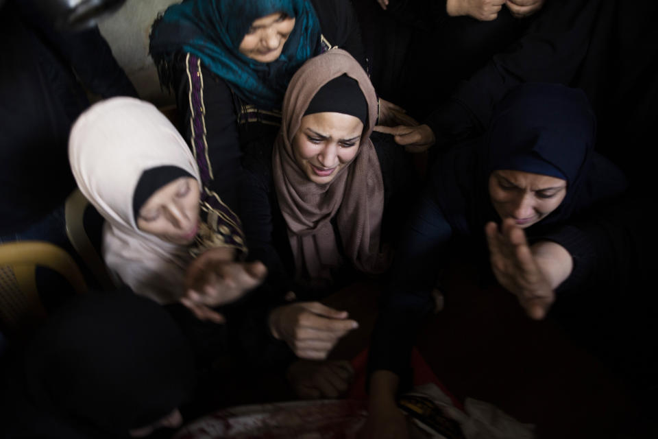 Relatives of Islamic Jihad militant, Abdullah Al-Belbesi, 26, who was killed in Israeli airstrikes, mourn his death in the family home, during his funeral in the town of Beit Lahiya, Northern Gaza Strip, Wednesday, Nov. 13, 2019. Gaza's Health Ministry said Wednesday that more Palestinians have been killed by ongoing Israeli airstrikes, bringing the death toll in the escalation over the past two days to at least 18. (AP Photo/Khalil Hamra)