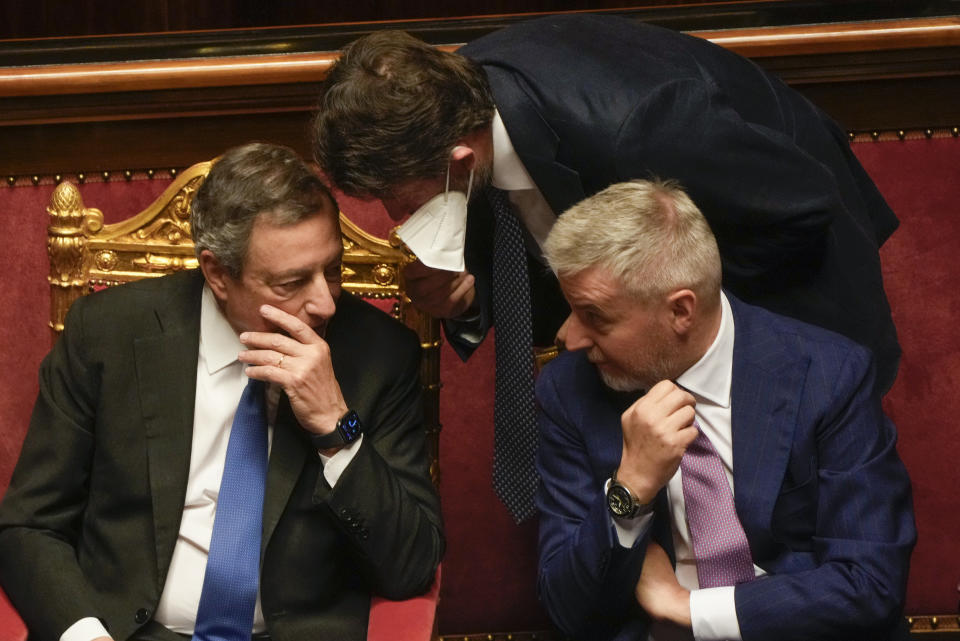 Italian Premier Mario Draghi, left, talks with culture minister Dario Franceschini, center, and defense minister Lorenzo Guerini during a debate at the Senate in Rome, Wednesday, July 20, 2022. Draghi was deciding Wednesday whether to confirm his resignation or reconsider appeals to rebuild his parliamentary majority after the populist 5-Star Movement triggered a crisis in the government by withholding its support. (AP Photo/Gregorio Borgia)